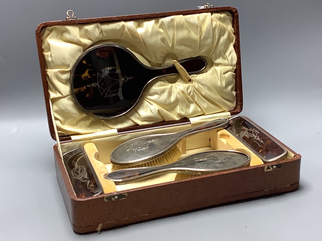 A cased George V silver and tortoiseshell mounted six piece mirror and brush set, maker Harper and Hassett Ltd, Birmingham 1927.